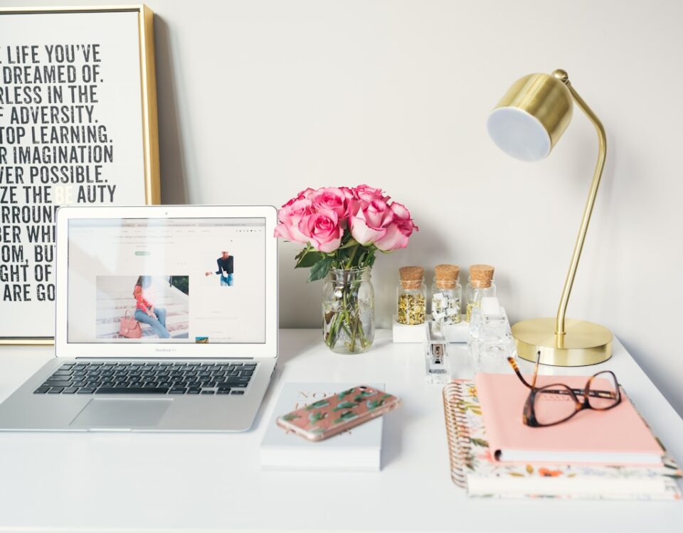 Mitos do Home Office: quais são os principais? MacBook Air beside gold-colored study lamp and spiral books