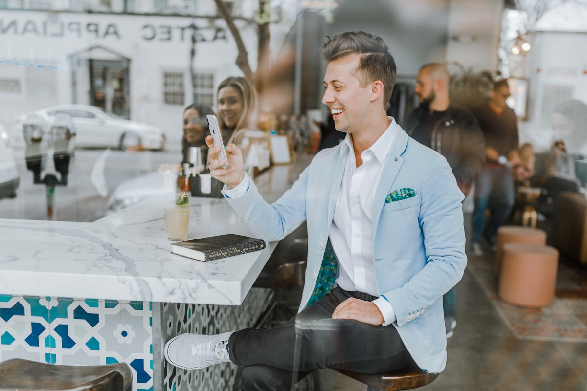 Avaliações online realmente influenciam as decisões de compra? smiling man while holding smartphone