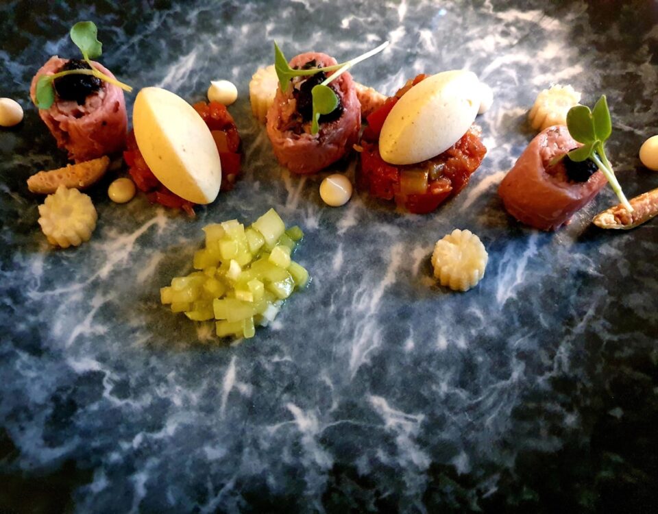 Como encontrar receitas raras com ingredientes difíceis? A black plate topped with different types of food