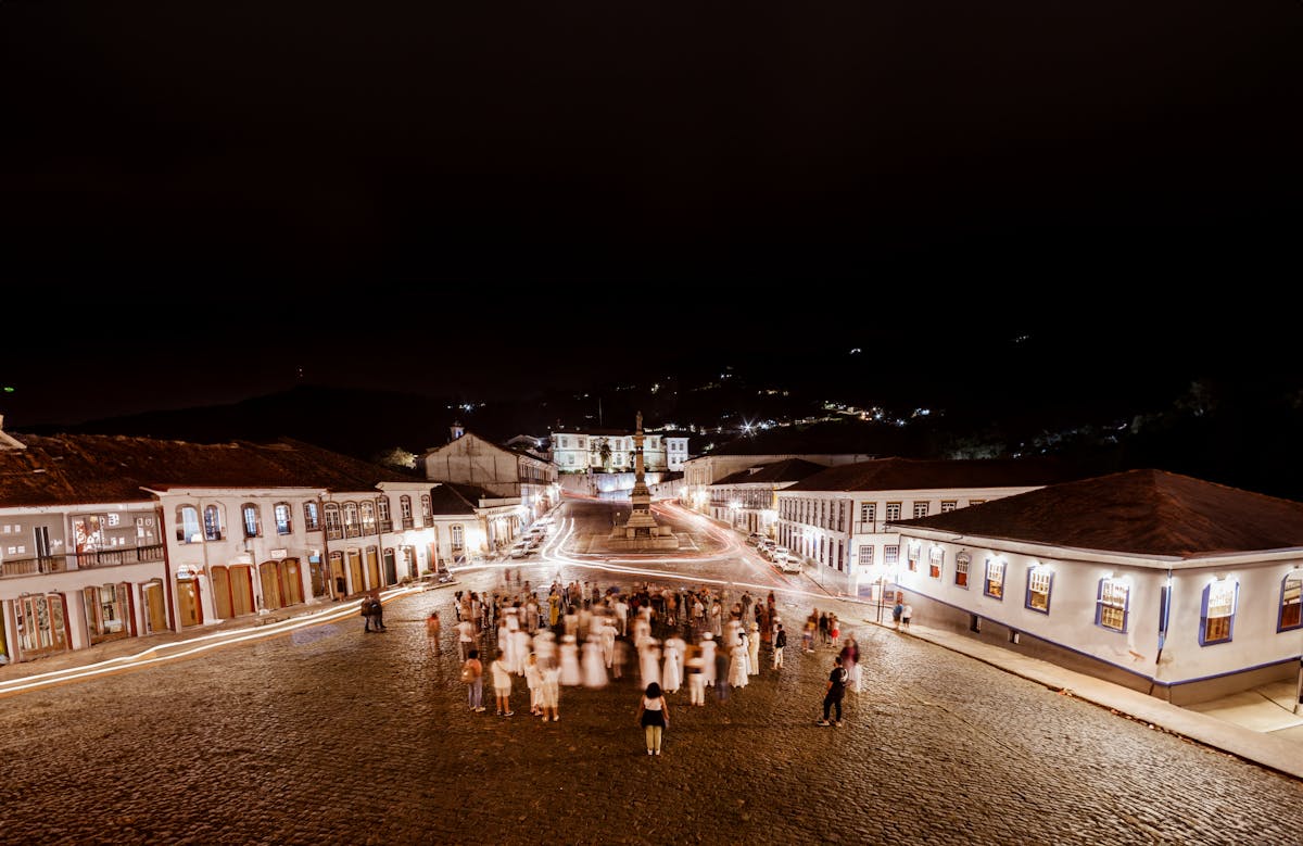 Qual cidade brasileira é ideal para turismo histórico e cultural? Aerial View of People Standing on the Town Sqaure at Night, Ouro Preto in Brazil