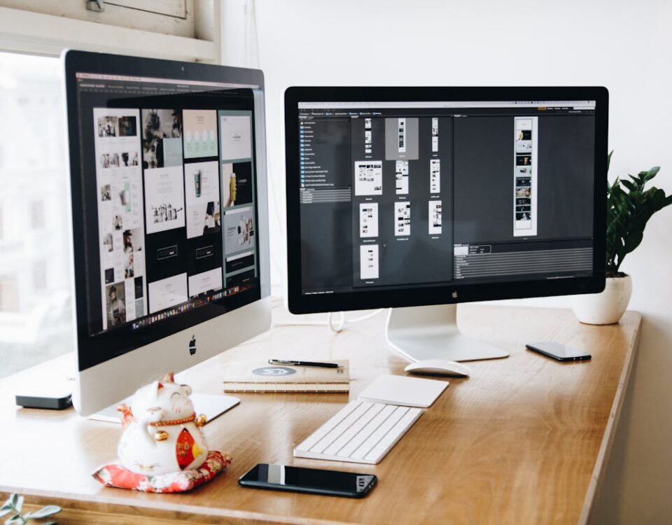 Como começar a criar um site para sua empresa? Two Imac's With Keyboard and Phones on Desk