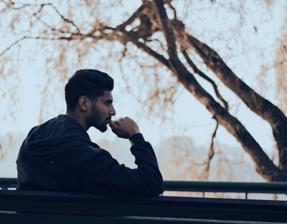 O estoicismo pode melhorar suas decisões? Man in Black Hoodie Sitting on Bench Near Green Trees