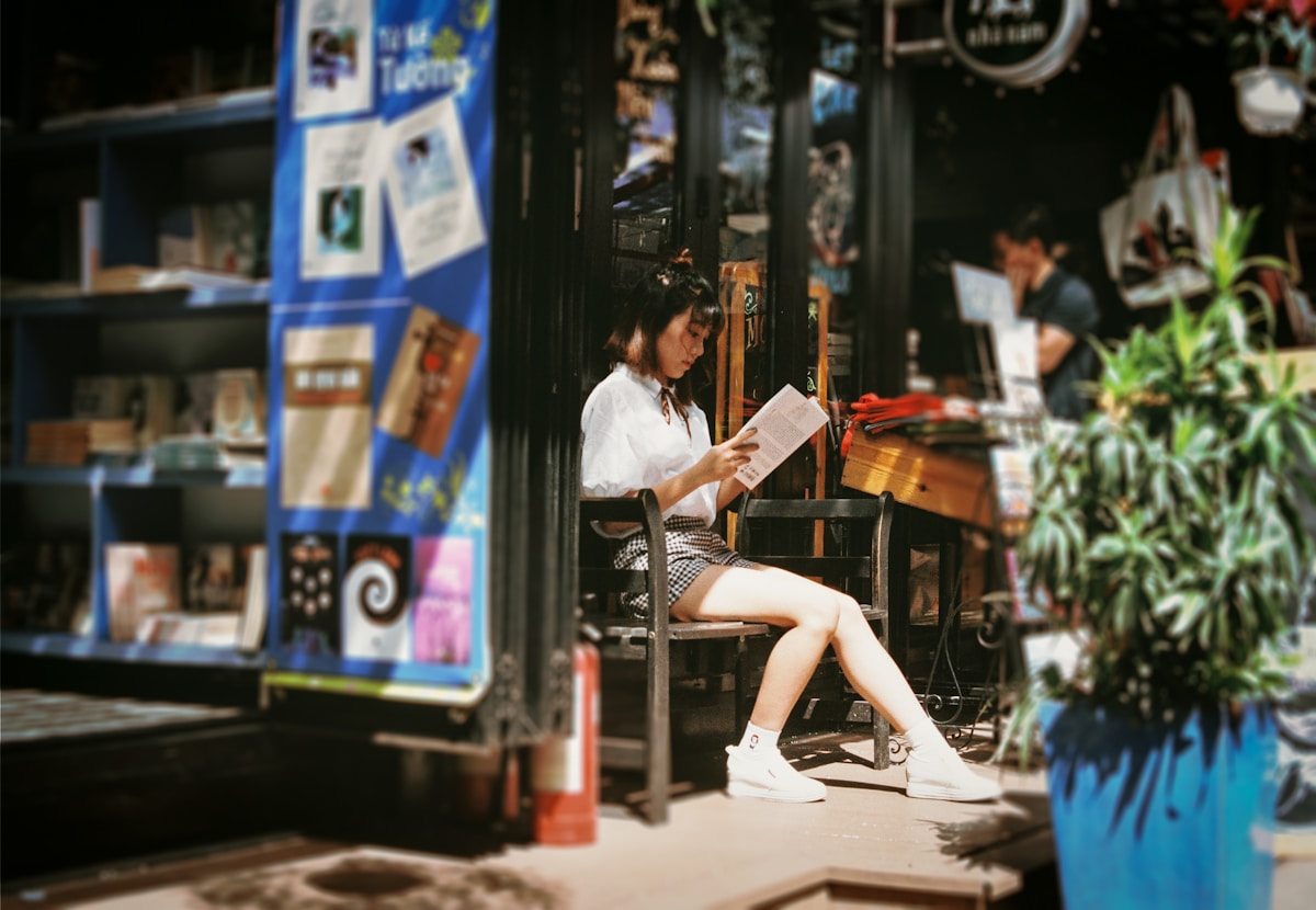 Qual livro clássico reflete melhor sua personalidade? woman reading book sitting on bench
