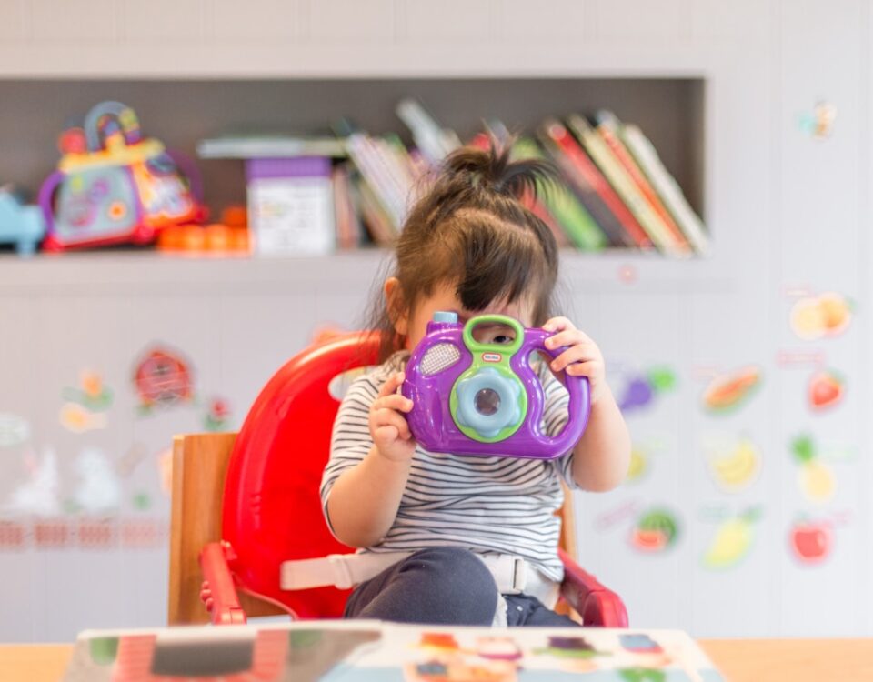 Como os brinquedos influenciam o desenvolvimento infantil girl holding purple and green camera toy