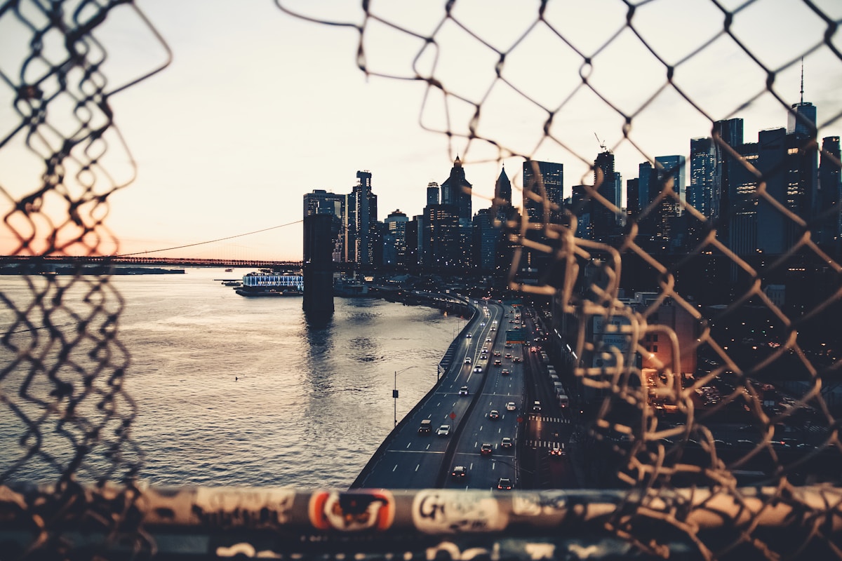 Qual cidade americana combina mais com sua personalidade? brown metal fence near body of water during daytime