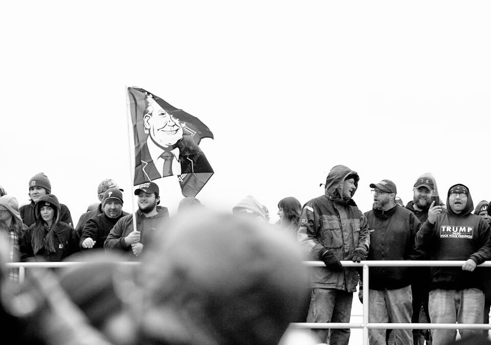 O que influencia mais: a mídia ou os partidos na política atual? grayscale photo of man holding flag