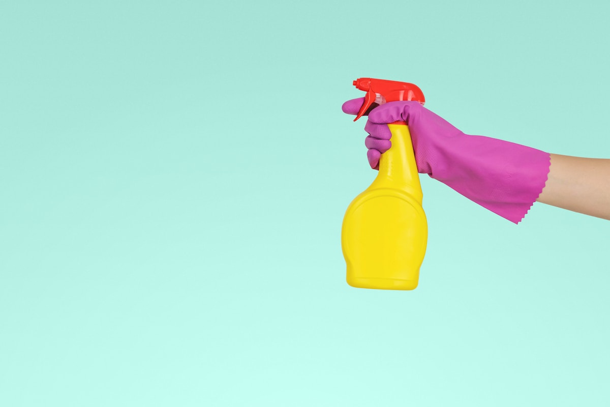 Devo usar produtos químicos para desentupir canos? person holding yellow plastic spray bottle