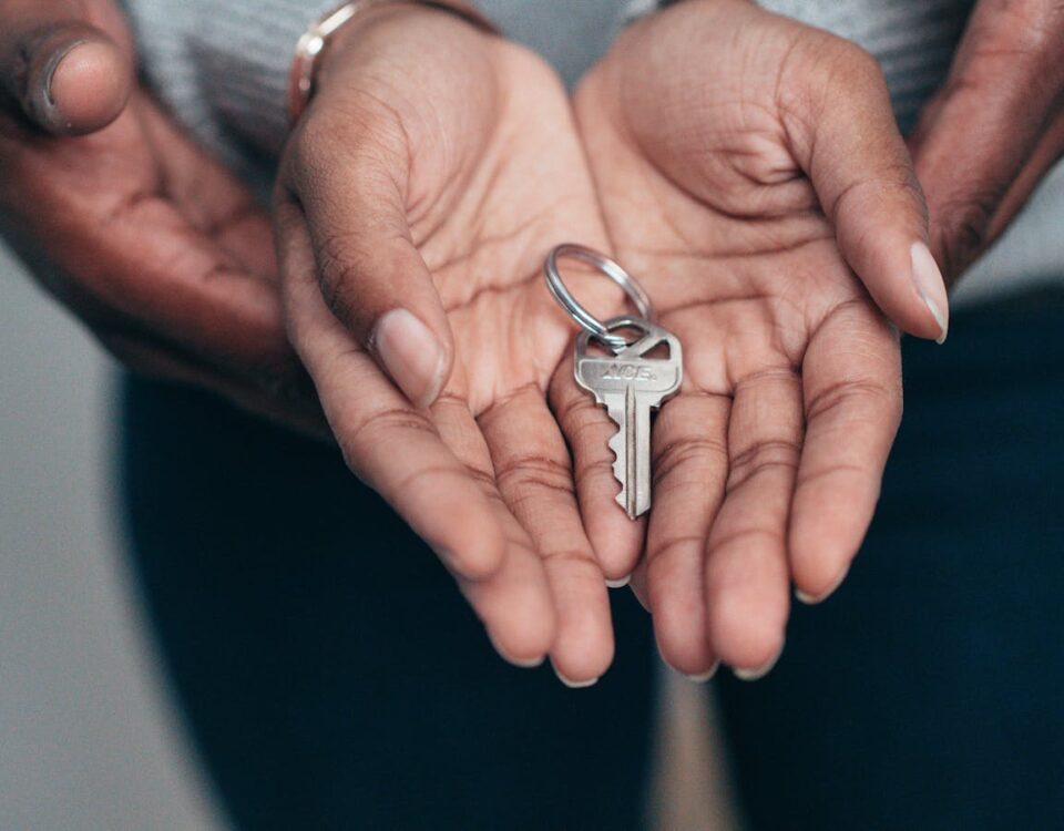 Qual a importância da segurança patrimonial nos dias atuais? Close-up of hands holding a key, symbolizing homeownership, real estate, and property investment.