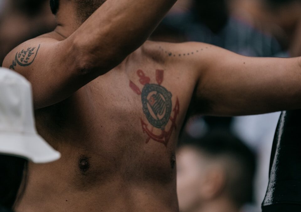Os melhores times de futebol paulistas | São Paulo A shirtless man holding a cell phone to his ear