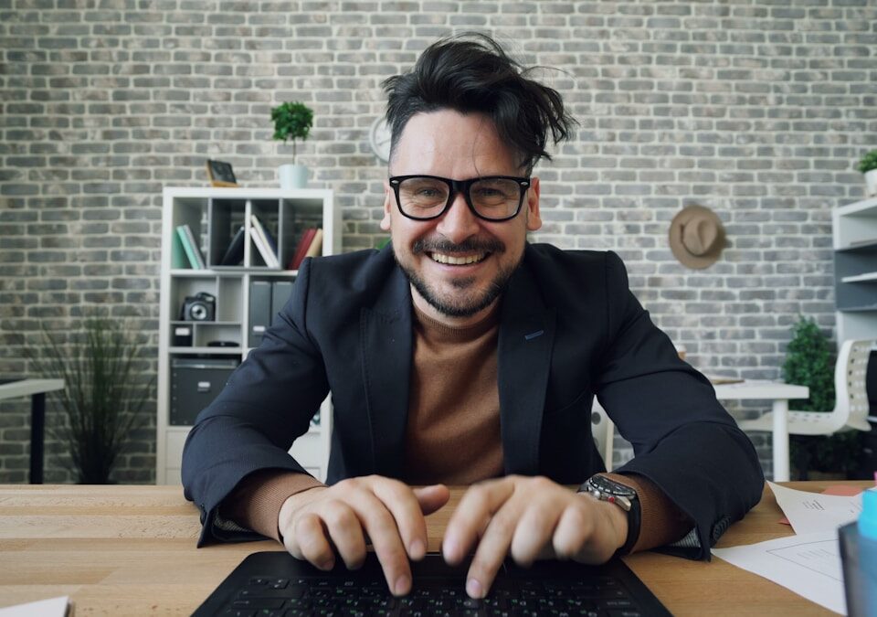 Como um robô pode melhorar o atendimento ao cliente a man sitting at a table with a laptop computer