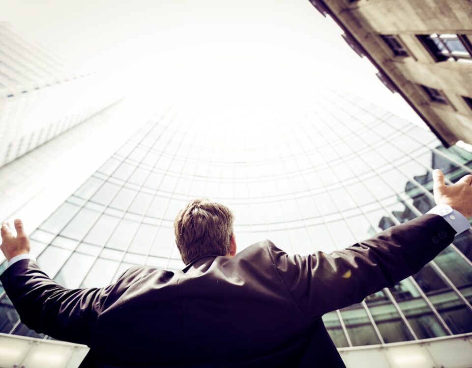 Qual é o segredo do sucesso no empreendedorismo? low-angle photography of man in the middle of buidligns