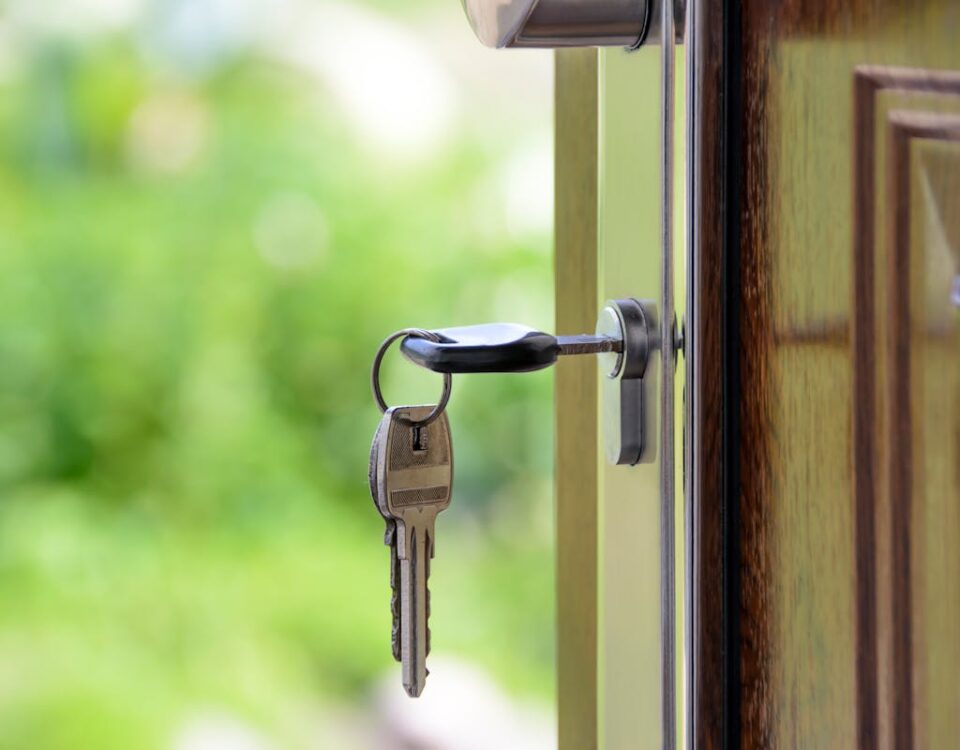 Quanto o mercado imobiliário pode crescer em 2025? Key inserted in door lock against a blurred green background, symbolizing security and real estate.
