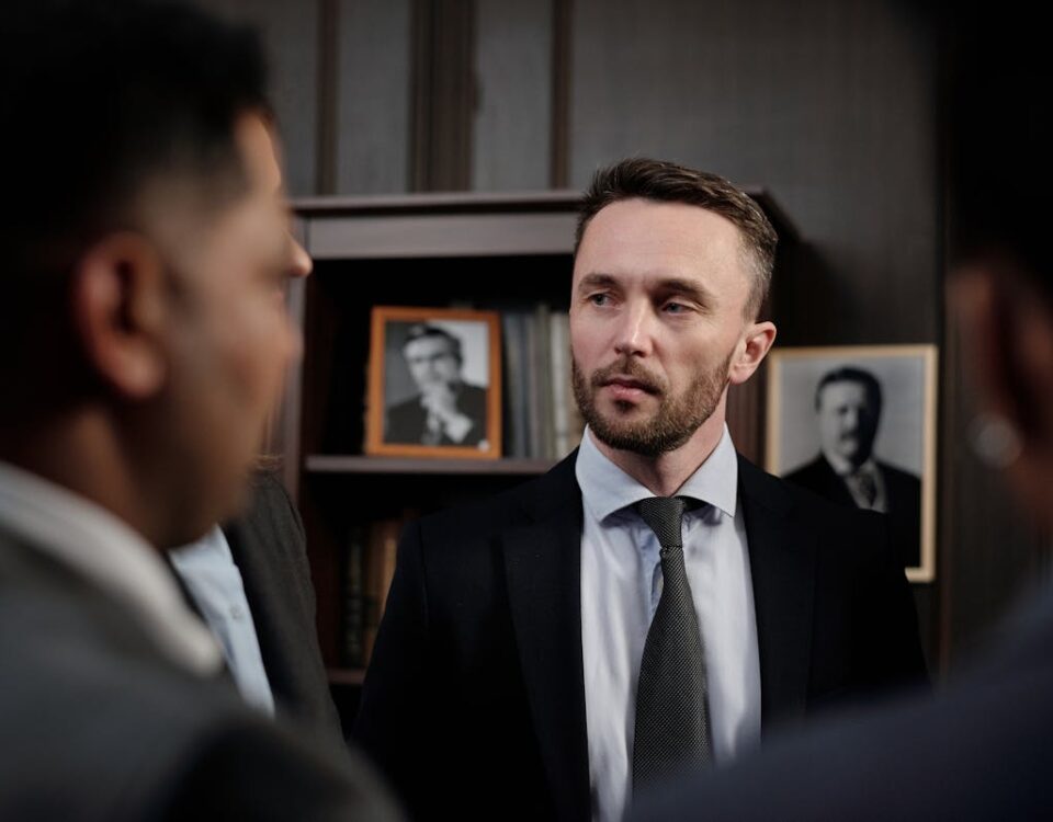 Como saber se um advogado criminalista é confiável? Group of men in suits having a serious business discussion in a professional setting.