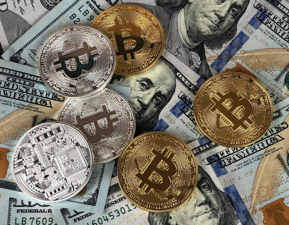 Criptomoedas vão substituir moedas tradicionais? Close-up of bitcoins and US dollar bills symbolizing modern finance and cryptocurrency.
