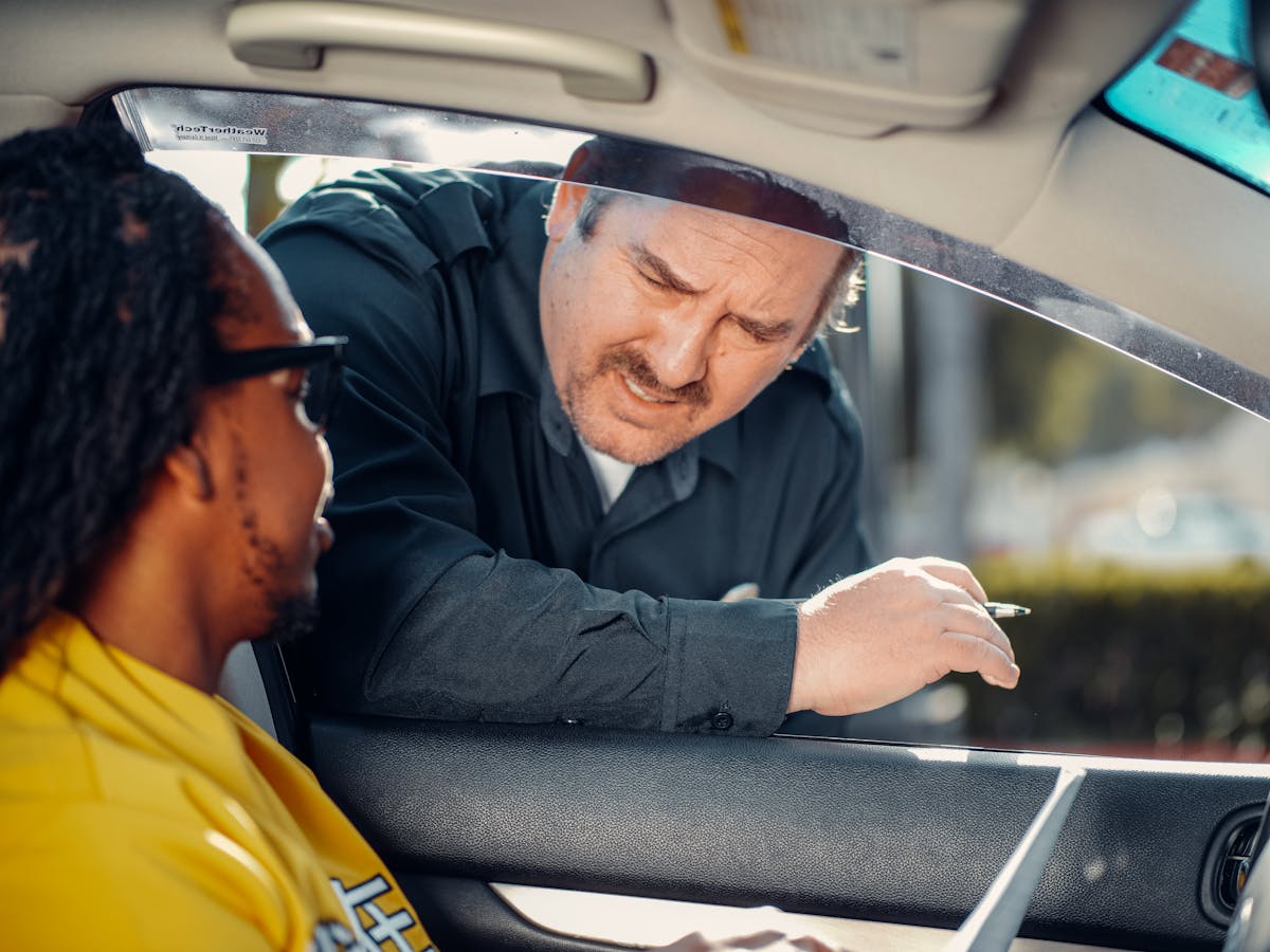 Por que a CNH tem validade? A police officer interacts with a driver through a car window, emphasizing law enforcement and public safety.