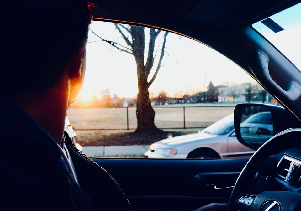 Por que algumas pessoas têm medo de dirigir? man sitting inside car looking at sun