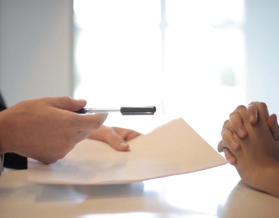 Contratar advogado para plano de saúde é sempre necessário? Close-up of a contract signing with hands over documents. Professional business interaction.