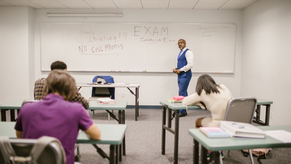 Professor fiscalizando estudantes durante uma prova