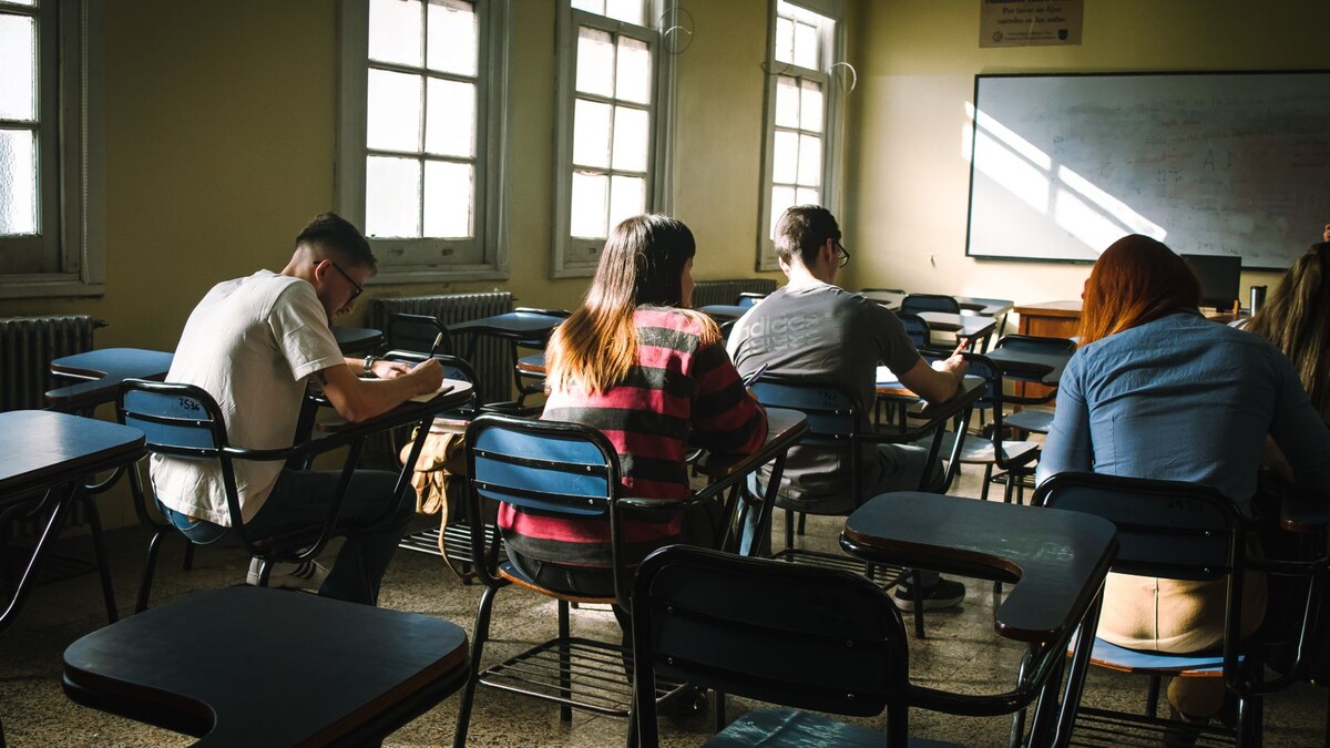 Estudantes concentrados em suas carteiras em sala de aula