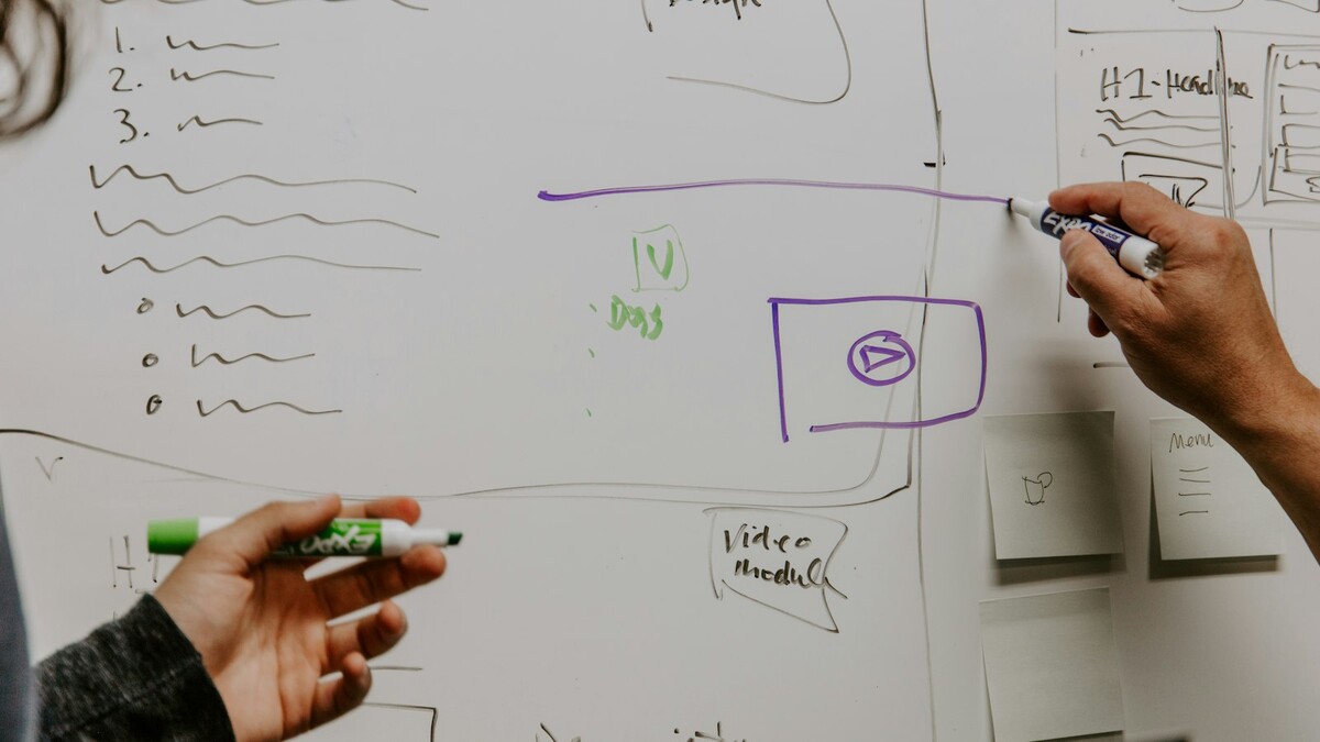 Duas pessoas planejando ideias em um quadro branco