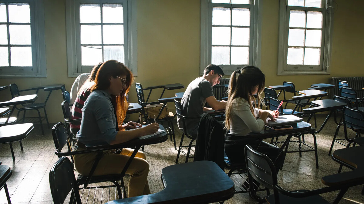 Alunos preenchendo prova em sala de aula