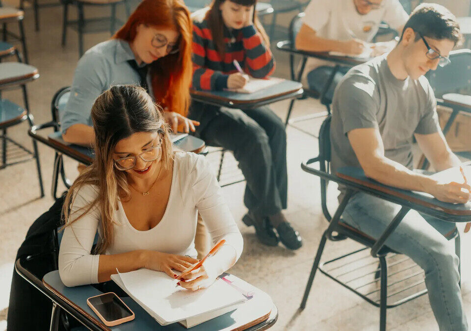 Estudantes universitários fazendo prova em sala