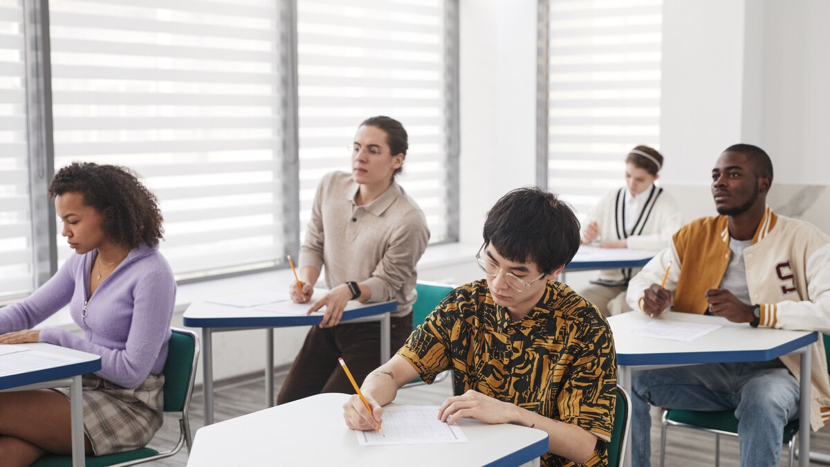 Estudantes escrevendo durante uma prova em sala de aula
