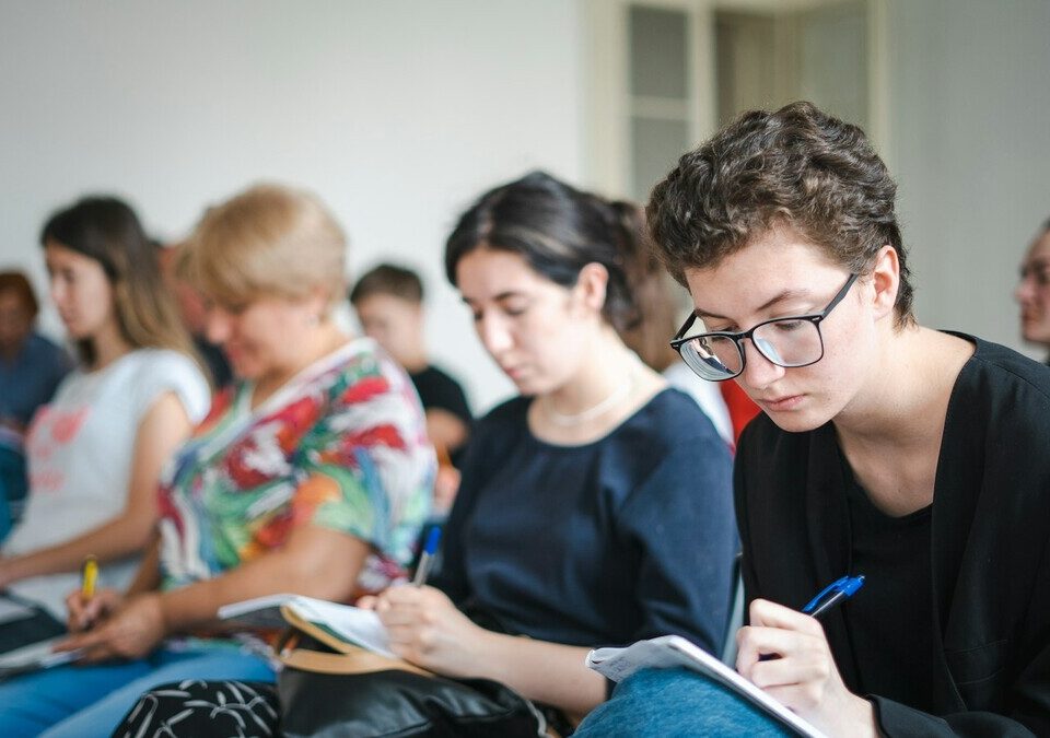 Grupo de estudantes sentados em uma sala de aula