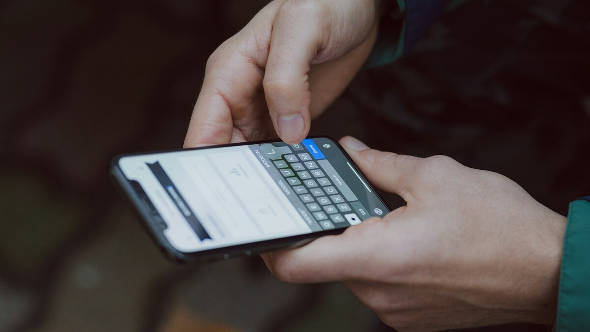 Por que o cliente manda só “oi” no WhatsApp e some depois? Mãos digitando uma mensagem no teclado de um smartphone