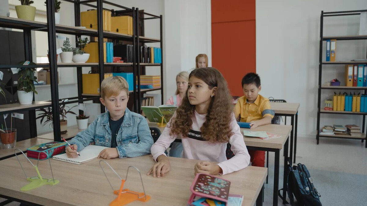 Trabalho infantil cai 9,2%: como reconhecer e denunciar situações Estudantes acompanham uma atividade escolar com livros e cadernos; imagem ilustrativa